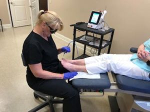 Patient receiving professional wound care for foot ulcer at clinic.